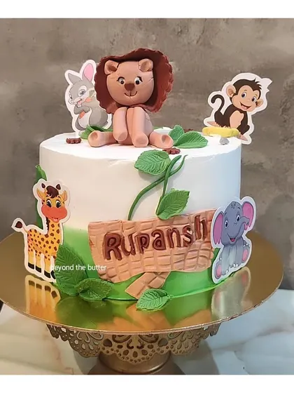 Another take on my popular jungle theme cake. This one features a friendly fondant lion, along with other cute animal toppers, perfect for a little explorer's birthday.