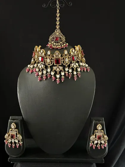 This red Victorian choker set is perfect for a bold reception look. The set includes the choker, matching earrings, and a maang tikka.