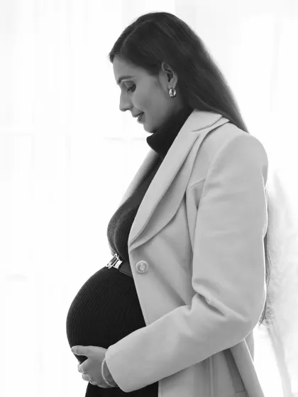 A soft and contemplative black and white portrait. The side profile against a bright window creates a beautiful, natural light silhouette that is both artistic and serene.