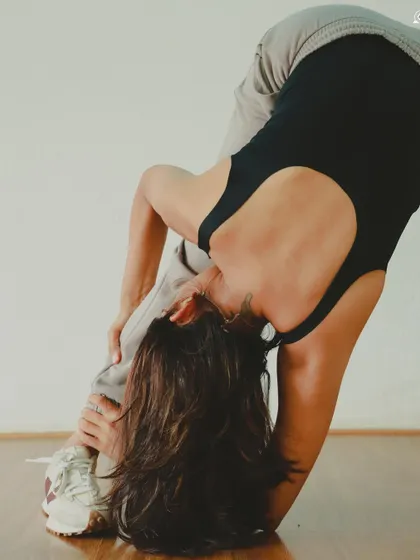 A playful variation of a standing forward bend, combining stretching with a sense of fun.