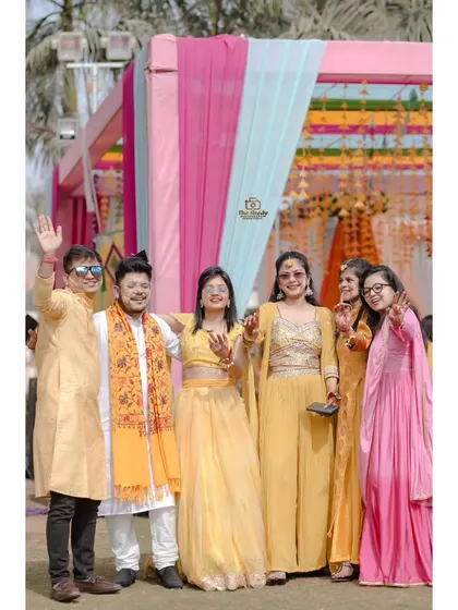 A happy group photo of friends and family at an outdoor Haldi ceremony. We make sure to capture all the important people celebrating with you.