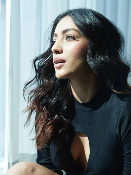 Keeping it simple and chic with Sahher Bambba. This black cutout top paired with jeans is a great example of a stylish, minimalist look for a casual photoshoot or appearance.