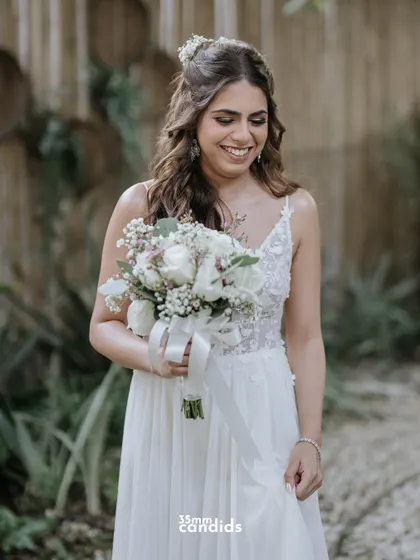 The bride, Trisha, in her beautiful white wedding gown, holding her bouquet. A simple, elegant portrait filled with happiness.