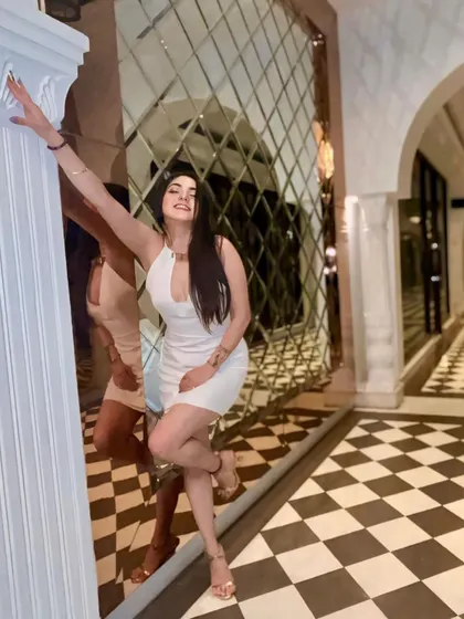 Another angle of the white mini dress, showing off its flattering fit and the fun, checkered floor of the venue.