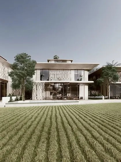 A view of the three Pavilion homes from across the paddy fields. The design uses a consistent architectural language of screens and overhangs, creating a harmonious relationship between the buildings and the vast agricultural landscape.