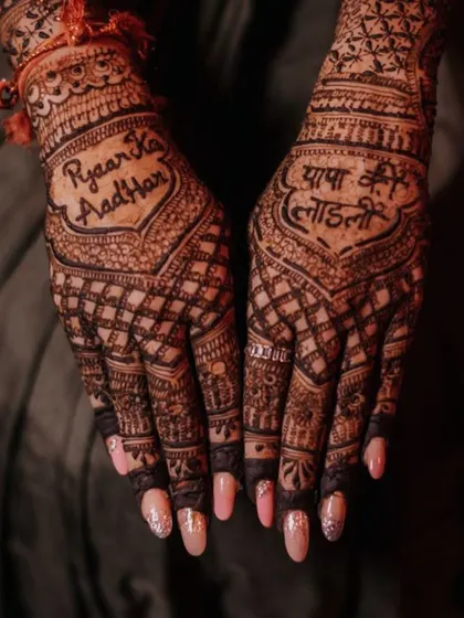 The dark stain of the henna makes the personalized text stand out beautifully against the intricate background design.