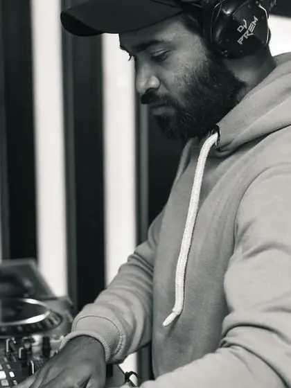 A candid black and white photo of me mixing. Whether it's a high-energy peak or a smooth transition, my focus is always on delivering a flawless set.