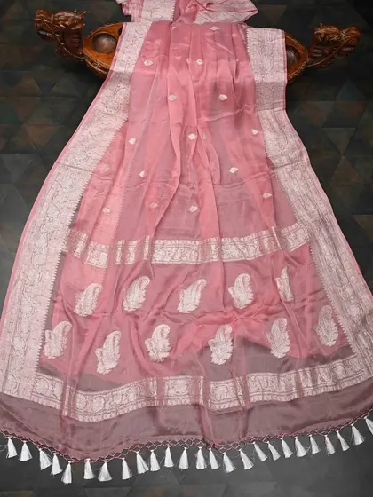 A beautiful pink chiffon saree with silver paisley motifs and an intricate silver border. It’s a lightweight and feminine choice for any special occasion.