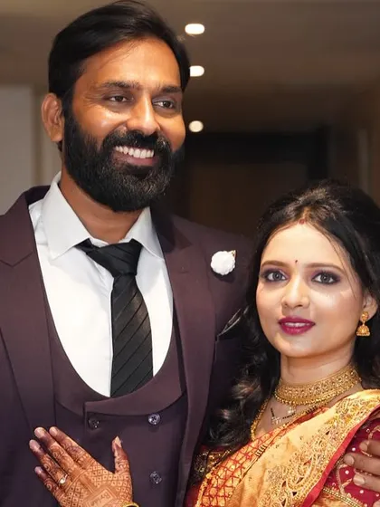 My beautiful client with her partner, ready for a wedding reception. Her makeup is soft and elegant, paired with a traditional red saree.