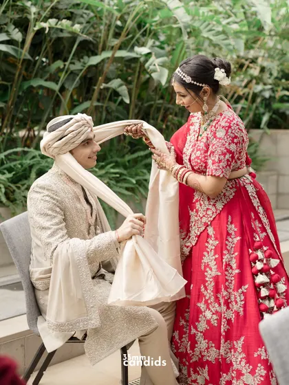A lovely moment where the bride helps the groom with his turban (safa), a gesture of care and partnership captured beautifully.