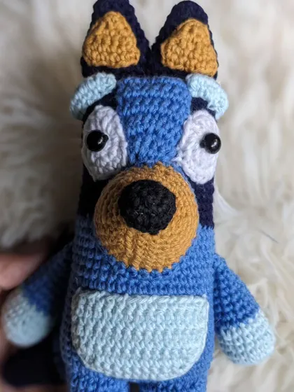 A hand-held shot of the Bluey amigurumi, showing its size.