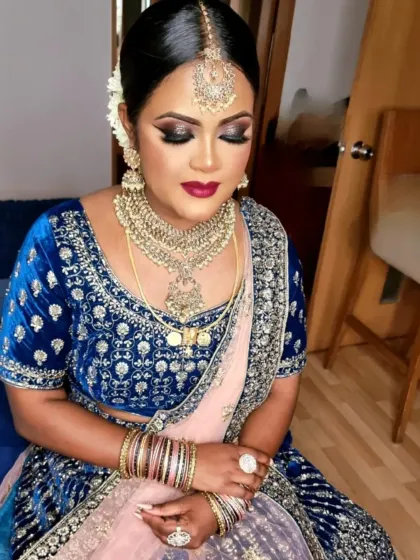 A bold and beautiful look with a blue velvet lehenga. The makeup is dramatic, with a dark smokey eye and a deep berry lip.