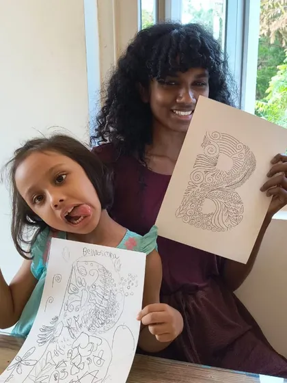 The "Crazy B's" team up. A student and instructor have fun showing off their intricate zentangle letter 'B' drawings.