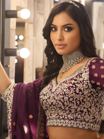 This pose showcases the intricate embroidery of the blouse and how the diamond choker sits. We discuss how makeup choices are influenced by the outfit's neckline and style.