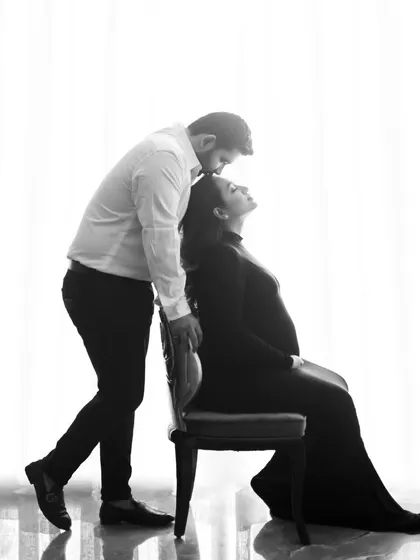 A timeless black and white silhouette. This artistic shot captures the quiet intimacy and anticipation of a couple during their maternity photoshoot.