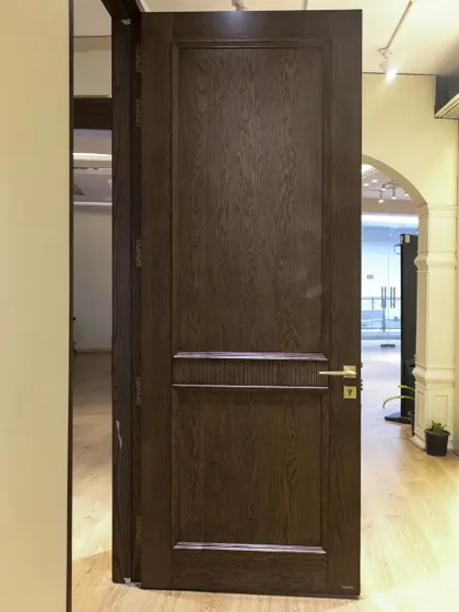 A real ash wood door with CNC-carved flutes and matching moldings. The dark stain brings out the natural grain of the ash, creating a rich and luxurious feel.