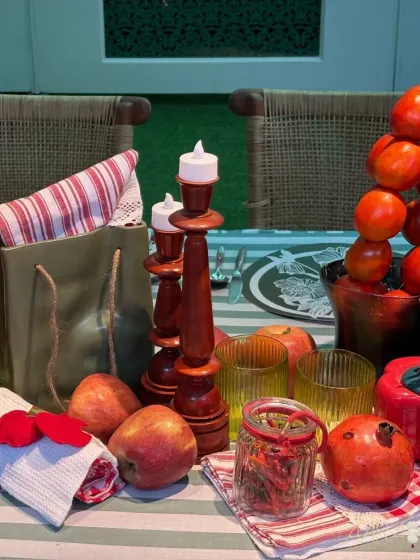 A vibrant table setting from the "Borough Bazaar" event, using fresh produce like tomatoes and pomegranates as decor. This farm-to-table aesthetic celebrates local, seasonal, and soulful elements, making the experience authentic and unique.