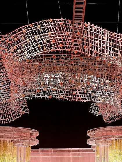 A direct view of the grand overhead structure, showing how it perfectly frames the two large pillar installations on the stage below. This demonstrates the architectural planning involved in our large-scale event designs.