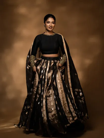 A full-length shot of this stunning black and gold tissue silk lehenga, perfect for a reception or sangeet.