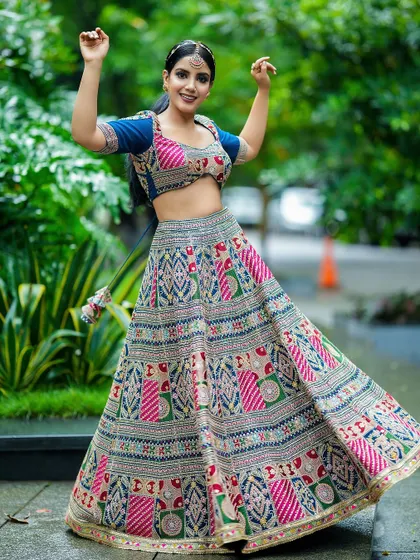A full-shot of the model twirling in a vibrant lehenga, showcasing the garment's beautiful flare and movement.