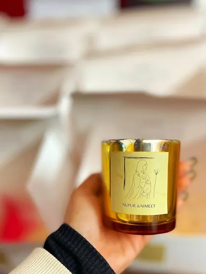 A personalized metallic jar candle from the baby shower order, featuring a custom illustrated label.