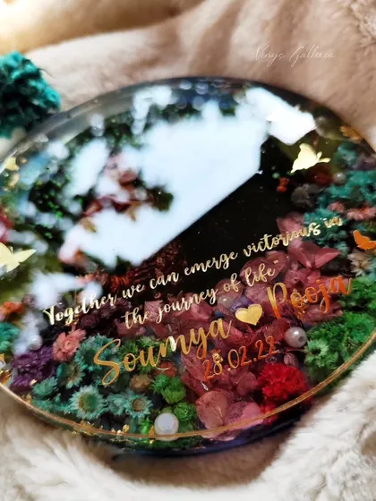 A close-up of a dreamy, multi-flower round frame created as an anniversary gift. The quote and names add a personal touch.