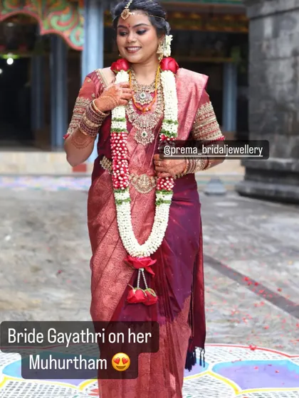 Bride Gayathri on her Muhurtham, looking lovely in a temple jewellery set with red stones.