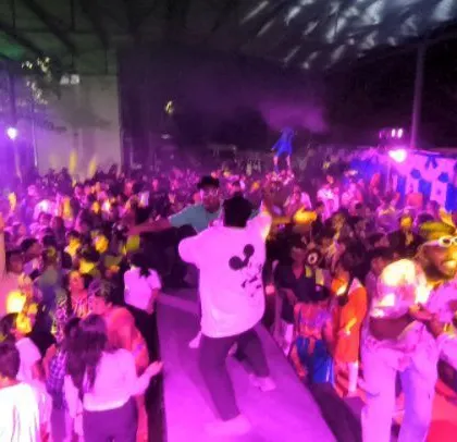The crowd is jumping and dancing at this packed corporate party.