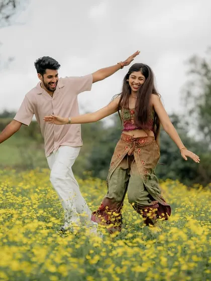 A playful, dance-like pose in the middle of a flower field. This shot is full of motion and joy, reflecting a fun-loving couple.
