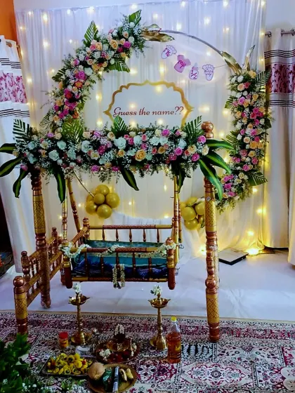 This cozy corner was transformed into a floral fairytale for a naming ceremony. The setup includes a beautifully decorated cradle, a floral ring, and fairy lights for a warm and traditional vibe.