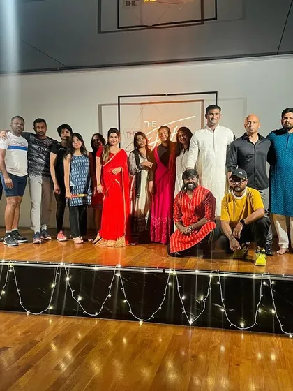 The organizing team and participants on stage at the end of a successful Dandiya event.