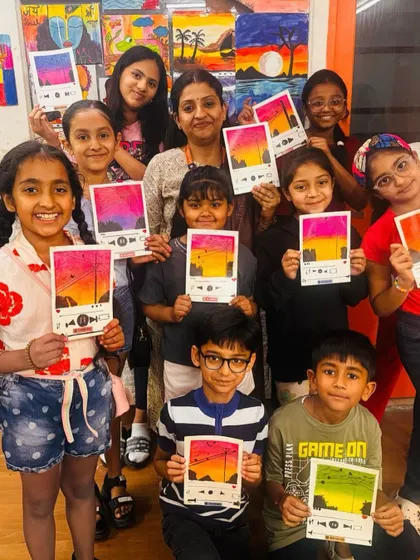 A group of proud artists with their trendy Spotify-style paintings. This workshop combines a love for music and art, as kids create a sunset scene using soft pastels on a "now playing" template.