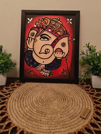 A beautiful Ganesha rendered in the Lippan art style. This piece combines traditional mirror work with vibrant colors to create a modern-traditional fusion.