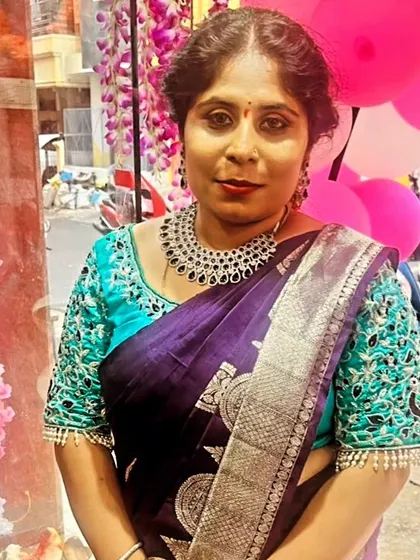 A client looking elegant in a purple silk saree with a heavily embroidered turquoise blouse for a party.