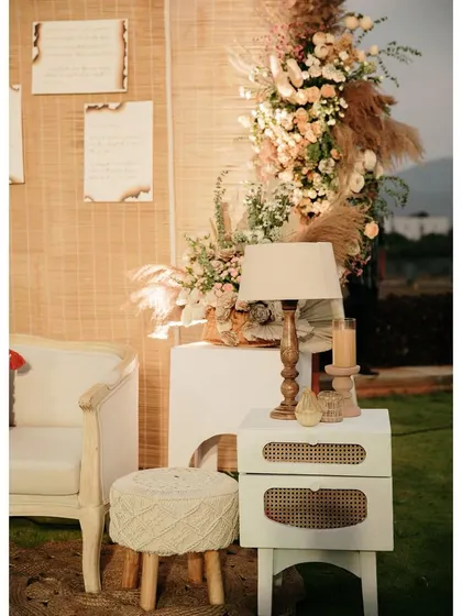 A cozy photo corner with a woven backdrop and comfortable seating.