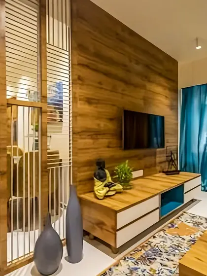 A simple yet effective TV unit design with a full wood-paneled wall. The low console offers storage, and the design is complemented by a slatted partition, adding a layer of visual interest.