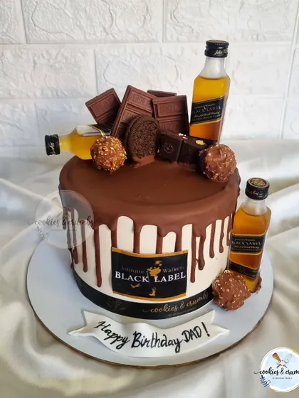 A chocolate lover's dream for a dad's 50th birthday. This drip cake is overloaded with chocolates, Ferrero Rocher, and Black Label miniatures.
