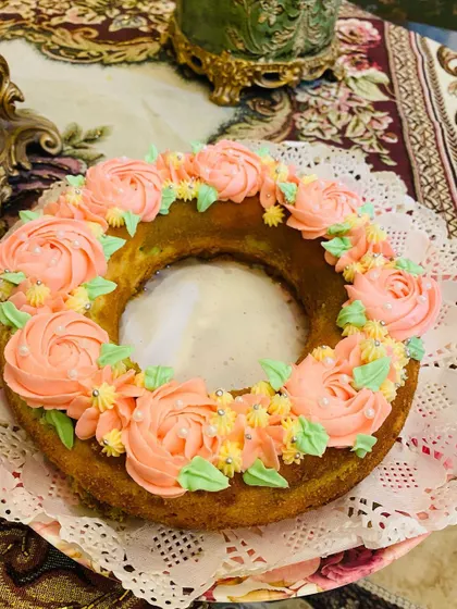 My Ribbon Bundt cake is decorated with a crown of hand-piped pink buttercream flowers, making it an elegant choice for any celebration.