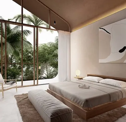 The bedroom in a Vagator Villa features a high, vaulted ceiling and a large window overlooking the Goan landscape. The design uses a minimal palette of wood and plaster to create a calm and earthy atmosphere.