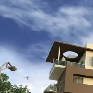 An exterior detail of a residential building, focusing on a cantilevered balcony roof with a circular cutout. This feature adds a unique geometric element to the facade while providing partial shade.