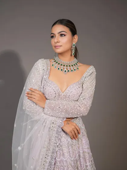 A professional shot of a modern, high-fashion bridal look. The makeup is clean and sharp, with a focus on the eyes and a strong contour.