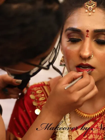 The art of makeup is in the details. Here, I am carefully applying eyeshadow and lipstick for Pooja, ensuring every element is perfect for her muhurtham.
