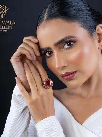 This ring features a large, cushion-cut ruby in a traditional, ornate setting. It is a piece that speaks of heritage and regal elegance, perfect for celebrating important milestones.