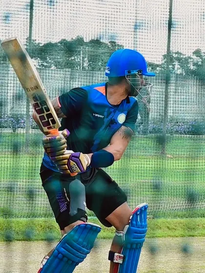 A professional player in full gear during a net session, showcasing the power and technique that we help refine.