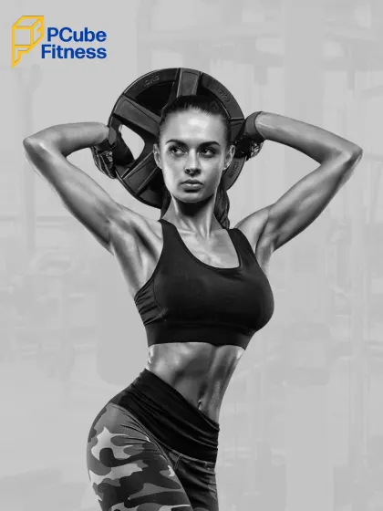 A black and white photo of a woman holding a weight plate, highlighting her defined abs and strong physique.