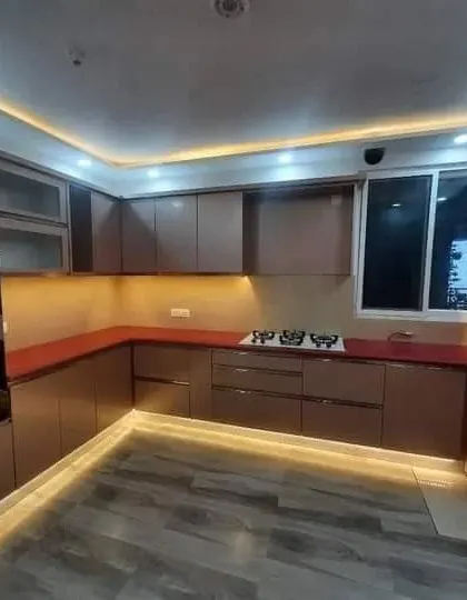 The U-shaped layout of this Southex kitchen provides plenty of counter space, illuminated by strip lighting under the cabinets and on the floor.