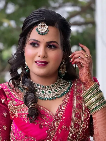 Supriya looking confident and beautiful for her reception. The hairstyle is a modern take on a classic half-updo with soft waves.