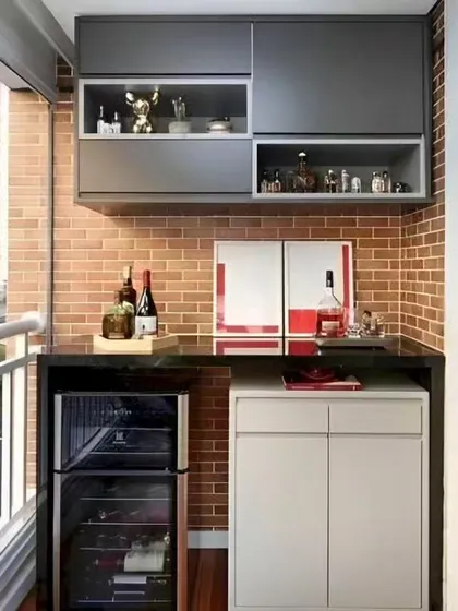 We converted this small balcony into a compact and stylish bar. The design features an exposed brick wall, a mini-friidge, and overhead cabinets for storing glasses and spirits.