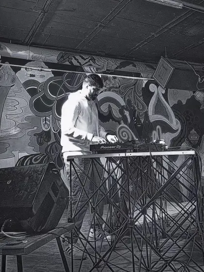 A black and white shot of me DJing against a cool, graffiti-style mural, showing a more artistic and urban side.