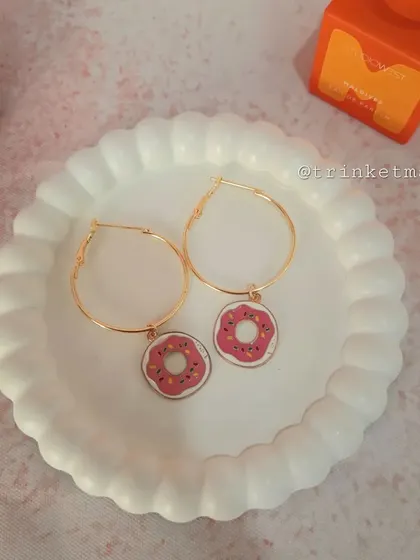 Sweeten up your style with these donut charm hoop earrings. The pink frosted donut with sprinkles is a fun and quirky accessory.